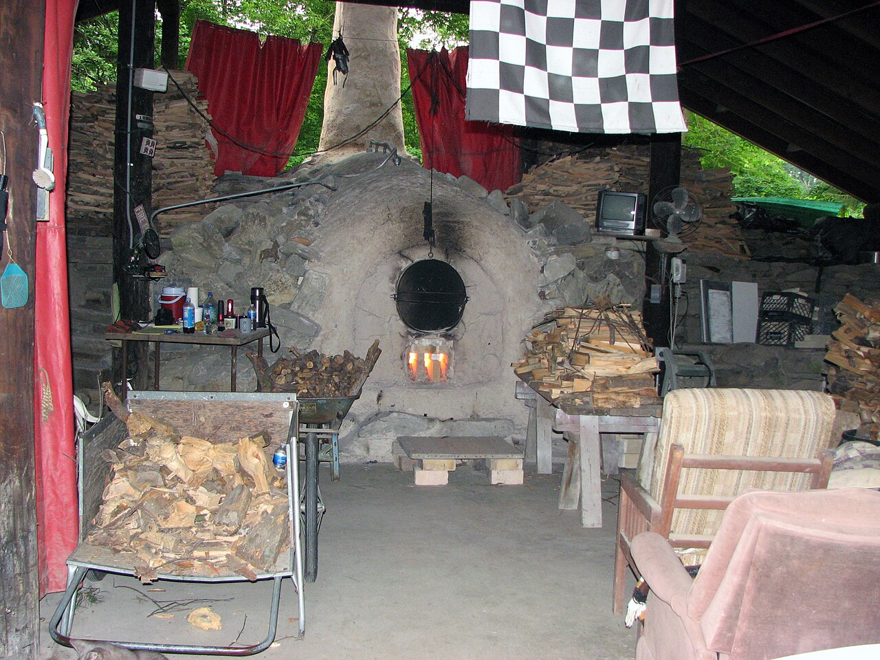 Four anagama en cours de cuisson, flammes et fumée sortant de la cheminée