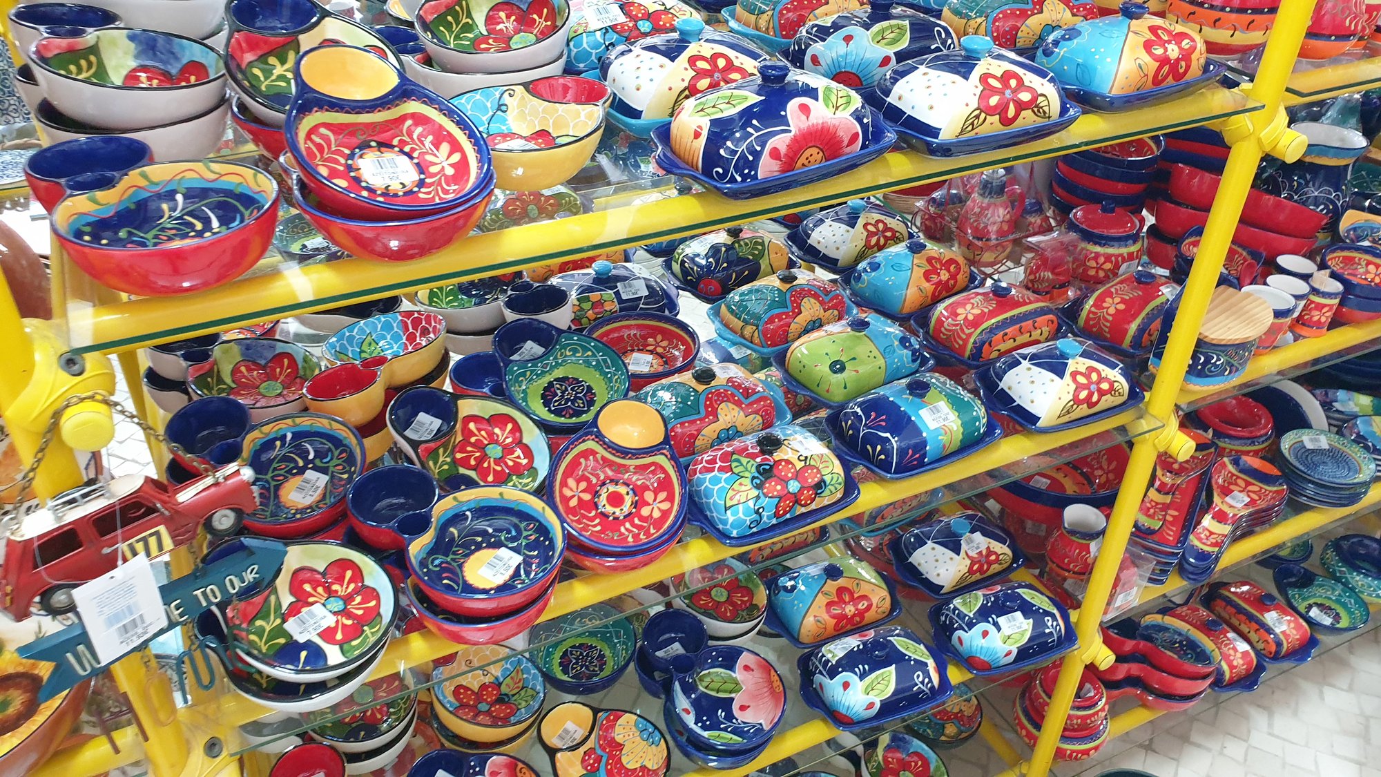 Collection de poteries et céramiques colorées alignées sur une étagère d'atelier