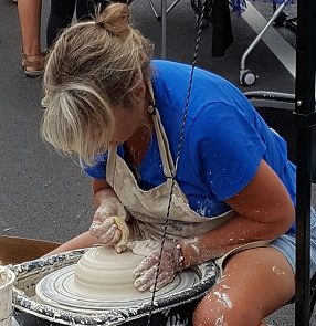 Mains de potier centrant une boule d'argile sur un tour