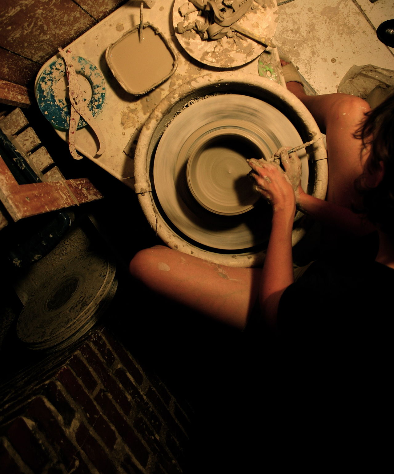 Artisan façonnant un vase de céramique au tour dans un atelier