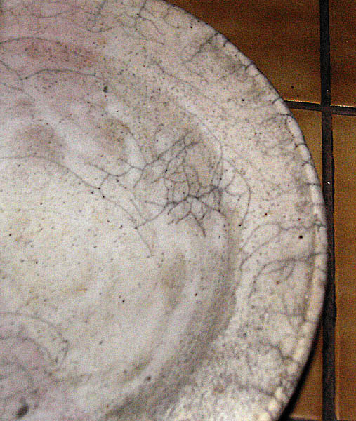 Detail de craquelure (krakelee) sur une piece raku, reseau de lignes noires de carbone dans l'email
